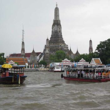 Wat Arun Tempel mit Booten auf dem Chao Phraya-Fluss in Bangkok, Thailand.