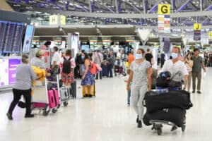 Die Abflughalle des Flughafen Suvarnabhumi in Bangkok mit vielen Toiristen die sich auf die Abreise vorbereiten.