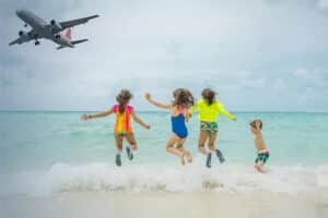 Kinder beim Spielen am Strand und ein Flugzeug befindet sich im Landeanflug auf Phuket