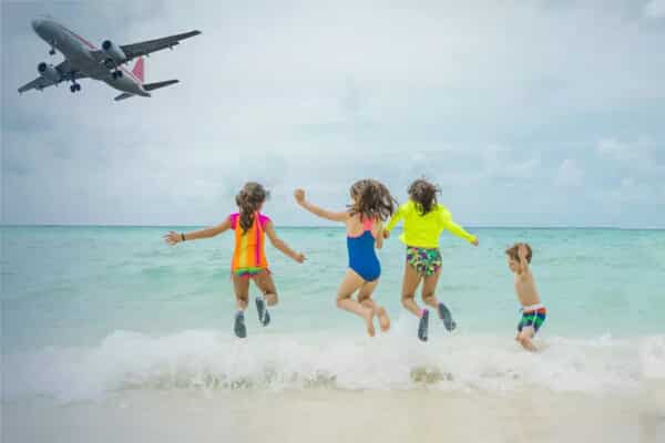 Kinder beim Spielen am Strand und ein Flugzeug befindet sich im Landeanflug auf Phuket