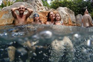 Eine Familie die mit ihren Kindern im Pool spielen