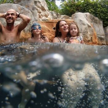 Eine Familie die mit ihren Kindern im Pool spielen