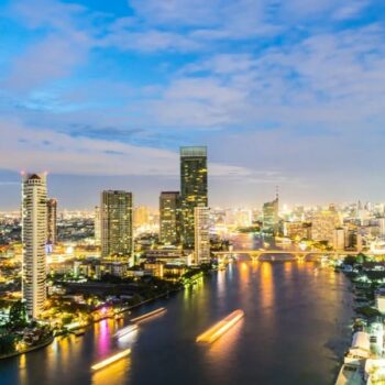 Chao Phraya Fluss in Bangkok bei Nacht, mit der Skyline von Bangkok im Hintergrund