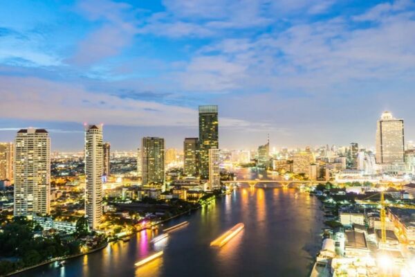 Chao Phraya Fluss in Bangkok bei Nacht, mit der Skyline von Bangkok im Hintergrund