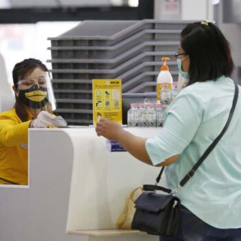 Passagierin am Schalter der Nok Air beim Einchecken für ihren Flug.