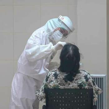 Eine Frau bei der Durchführung des PCR Tests in Bangkok