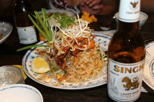 angerichtetes thailändisches Nudelgericht Pad Thai mit einer Flasche des bekannten Singha Bier