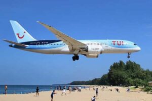 Flugzeug der TUI Gruppe beim Landeanflug auf Phuket, über dem Maikhao Strand.