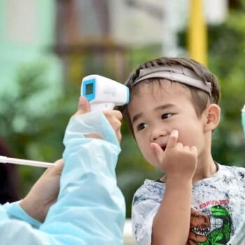 Temperaturkontrolle bei einem Baby, welches mit seinen Eltern in Bangkok gelandet ist.
