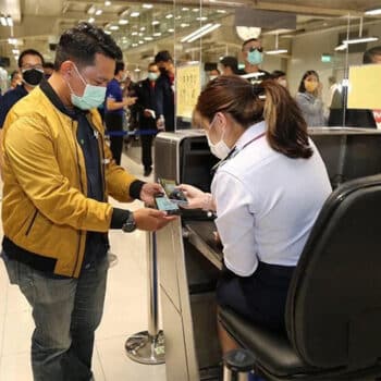 Tourist bei der Kontrolle der Dokumente am Flughafen von Bangkok