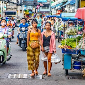 Das typische Straßenbild von Thailand mit vielen Scootern, Shops und Passanten.