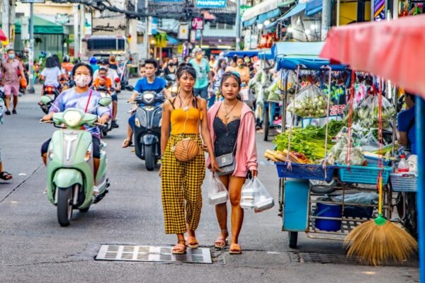 Das typische Straßenbild von Thailand mit vielen Scootern, Shops und Passanten.