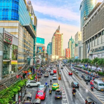 Eine von Bangkok bekannten Straßen mit Shopping Centren und bunten Taxis.