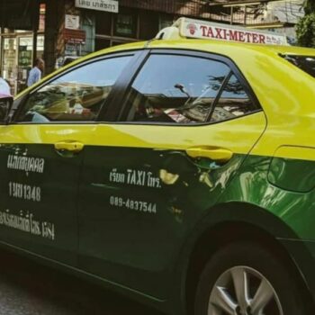 ein buntes thailaendisches Taxi in den Farben gelb und gruen