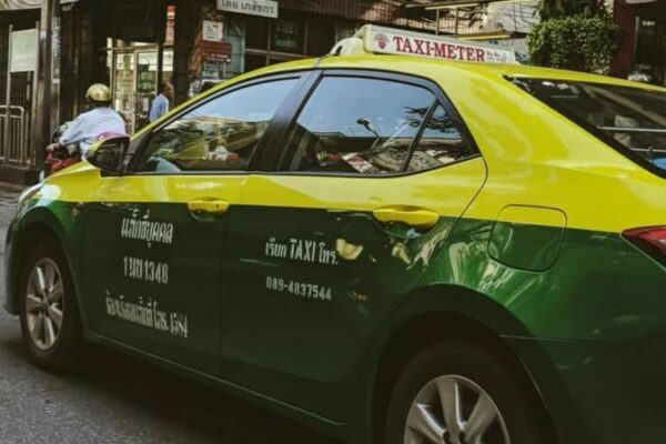 ein buntes thailaendisches Taxi in den Farben gelb und gruen