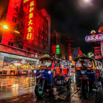 2 Tuk Tuks in den Straßen von China Town in Bangkok bei Nacht.