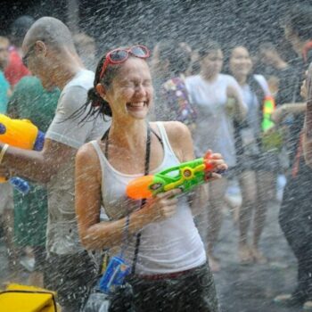 Touristen bei der für Songkran typischen Wasserschlacht mit Wasserpistolen in der Khao San Road.