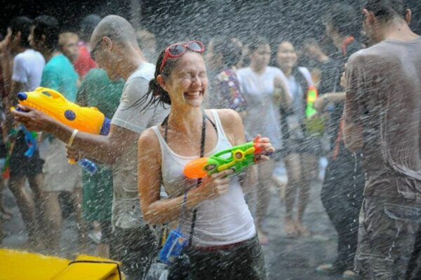 Touristen bei der für Songkran typischen Wasserschlacht mit Wasserpistolen in der Khao San Road.