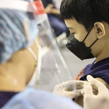 Thailändischer Junge welcher seine Corona Impfung erhält.