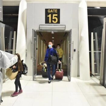 Passagiere die Am Flughafen von Phuket das Flugzeug verlassen und von Mitarbeitern des Flughafens in Empfang genommen werden.