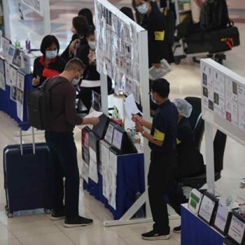Touristen am Flughafen von Bangkok bei der Einreisekontrolle.