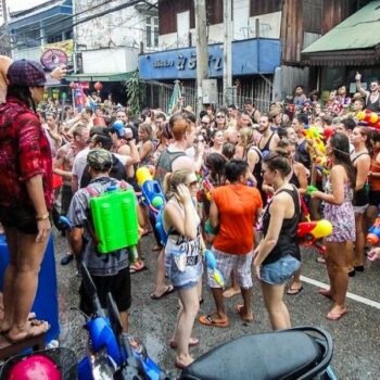 Touristen und Thais mit Wasserpistolen bewaffnet auf den Straßen von Bangkok, das Songkran Fest feiern.