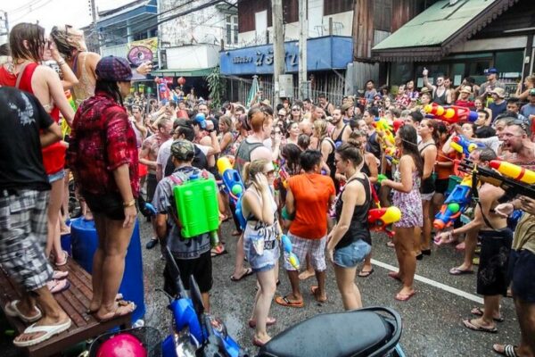 Touristen und Thais mit Wasserpistolen bewaffnet auf den Straßen von Bangkok, das Songkran Fest feiern.