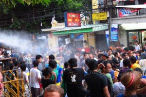 Touristen und Thais beim feiern des Songkran Fest in der Khao San Road.