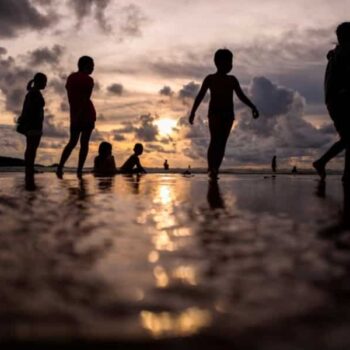 russische Touristen am Strand von Phuket in der Abenddaemmerung.