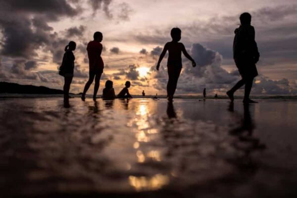 russische Touristen am Strand von Phuket in der Abenddaemmerung.