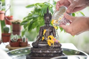 Traditionelles übergiessen einer Buddha Statue zu Songkran.