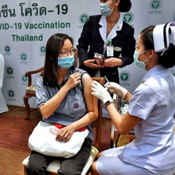 Eine Thailänderin bei der Verabreichung ihrer Covid-19 Impfung.