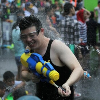 Thailänder bei der zu Songkran typischen Wassertschlacht mit Wasserpistolen.