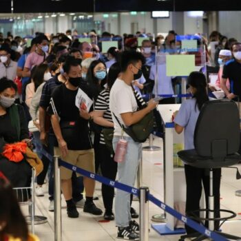 Fluggäste am Bangkoker Flughafen beim passieren des Thailand Pass Kontrollpunktes.