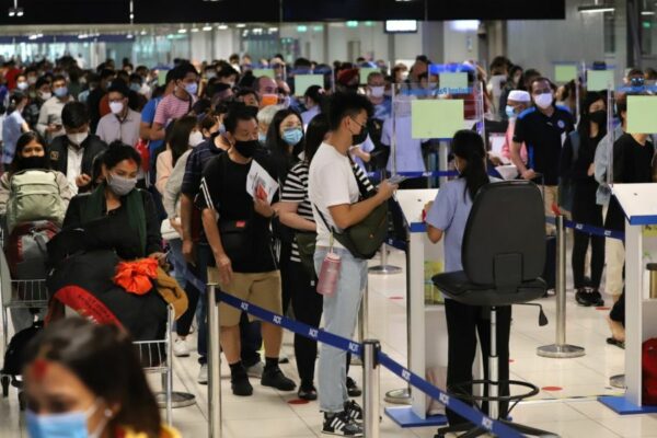 Fluggäste am Bangkoker Flughafen beim passieren des Thailand Pass Kontrollpunktes.