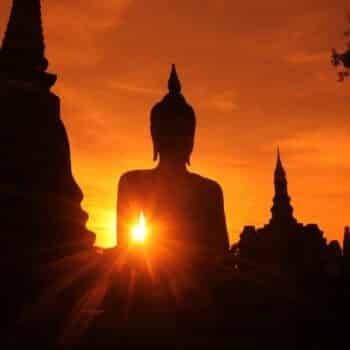 Eine thailändische Buddha Statue bei Sonnenuntergang in Ayutthaya.