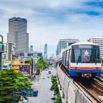 Eine BTS beim Einfahren in eine Station auf der Sukhumvit Line in Bangkok, Thailand.