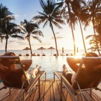 Thailand Touristen am Pool im Liegestuhl liegend mit Blick auf die Andamanensee.