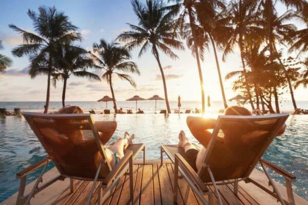 Thailand Touristen am Pool im Liegestuhl liegend mit Blick auf die Andamanensee.