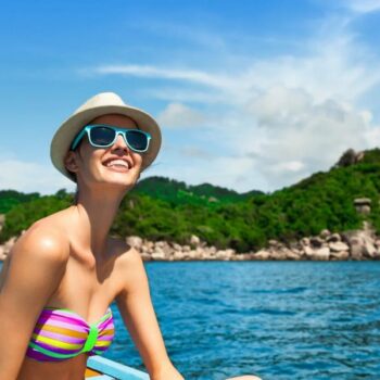 Eine Thailand Touristin in einem Longtailboot vor den Similan Inseln in Thailand.