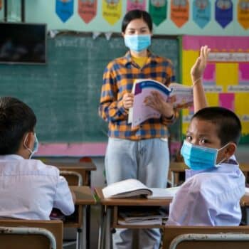 thailändische Kinder in der Schule, die im Unterricht eine Maske tragen.