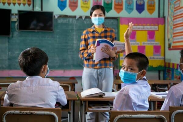 thailändische Kinder in der Schule, die im Unterricht eine Maske tragen.