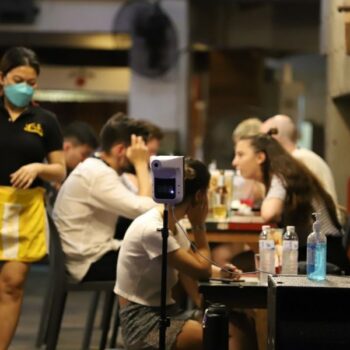 Ausländer und Einheimische werden ohne Gesichtsmasken in einer Bar in Bangkok gesehen.
