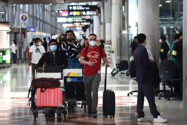 Bei der Ankunft am Flughafen Suvarnabhumi gehen die Touristen durch das Terminal.