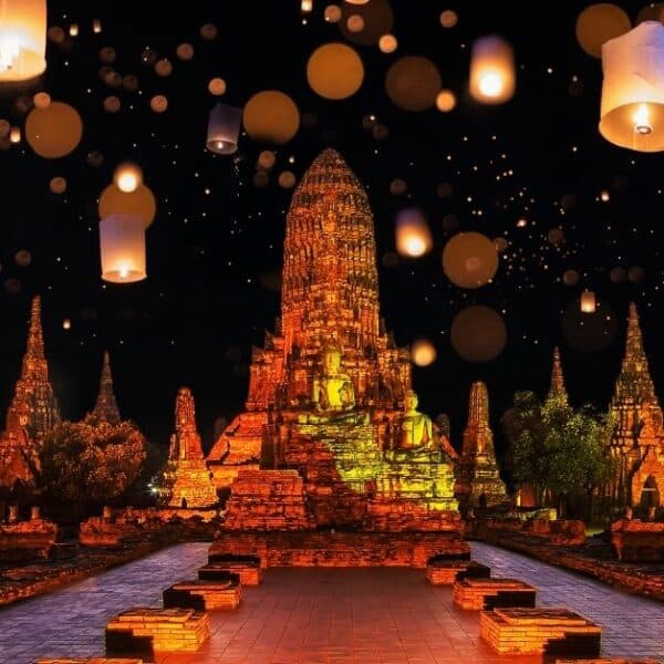 Tempel in Thailand beleuchtet mit Laternen während des Loy Krathong Festes, mit dem Text Feiertage in Thailand 2023.