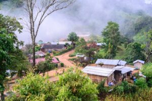 Traditionelles Lisu-Bergdorf in den Bergen von Chiang Mai, Thailand, umgeben von Nebel und grüner Natur