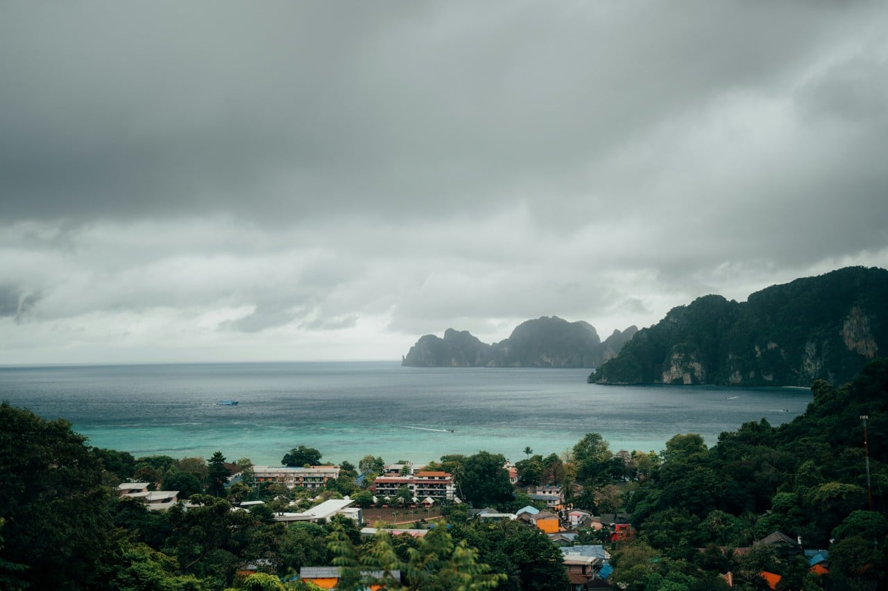 Blick auf die Küste Südthailands während der Regenzeit mit bewölktem Himmel und ruhigem Meer