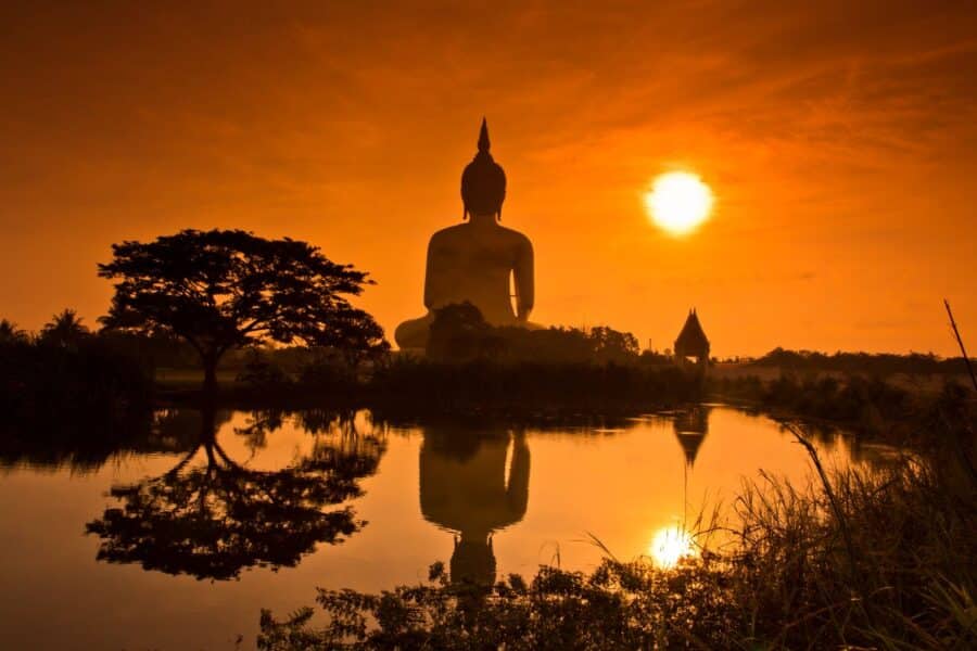 Große Buddha Statue in Thailand bei Sonnenuntergang als Symbol für Ruhe und sicheres Reisen