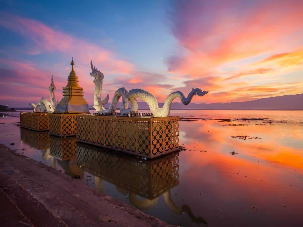 Naga-Skulptur am Kwan Phayao See bei Sonnenuntergang während einer Loy Krathong Rundreise durch Nordthailand