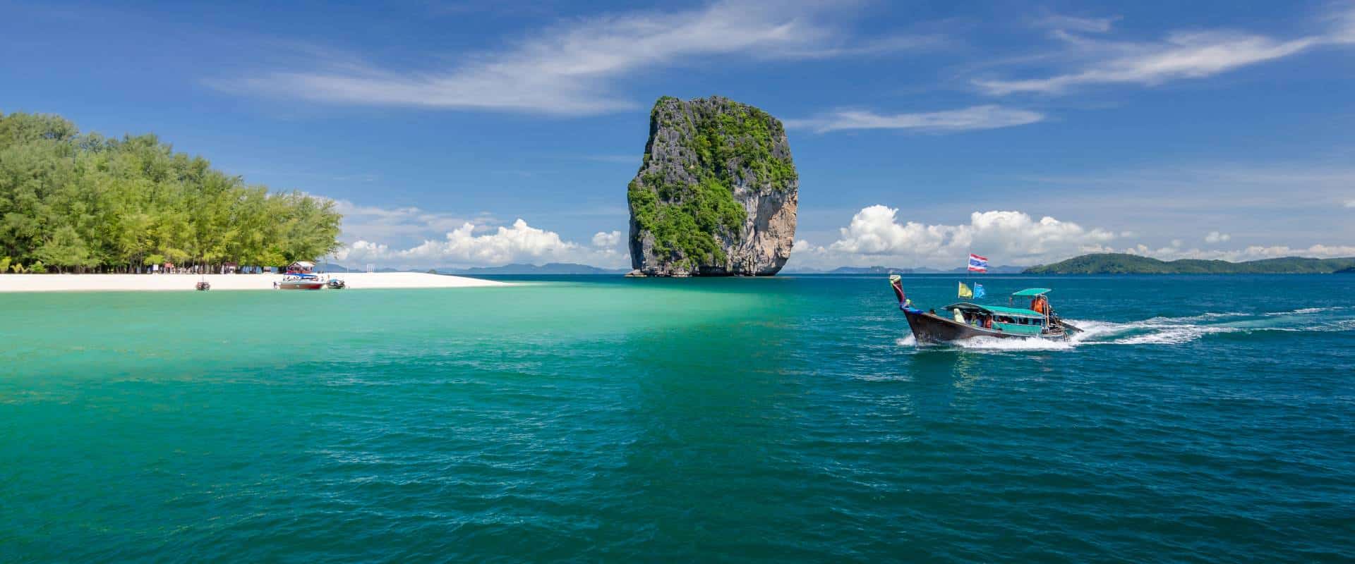 Badeurlaub in Krabi mit Longtailboot vor tropischer Insel in Thailand